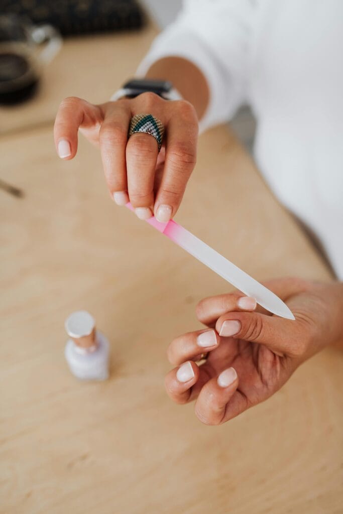 A close-up of a hand filing nails during a home manicure session. Perfect for beauty and self-care concepts.